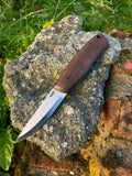 Bushcraft knife with walnut handle on stone