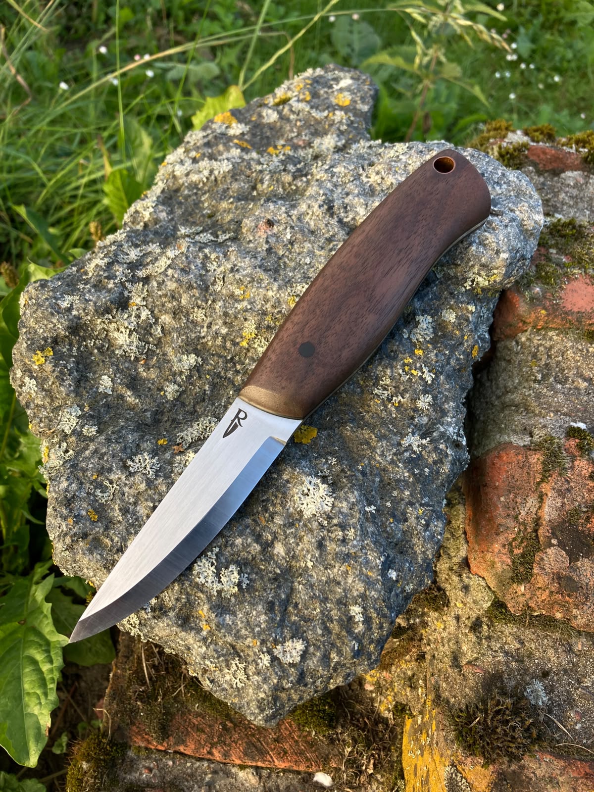 Bushcraft knife with walnut handle on stone