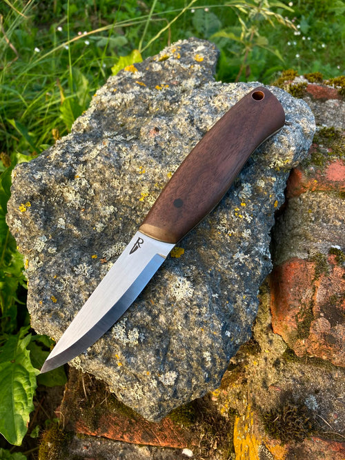 Bushcraft knife with walnut handle on stone